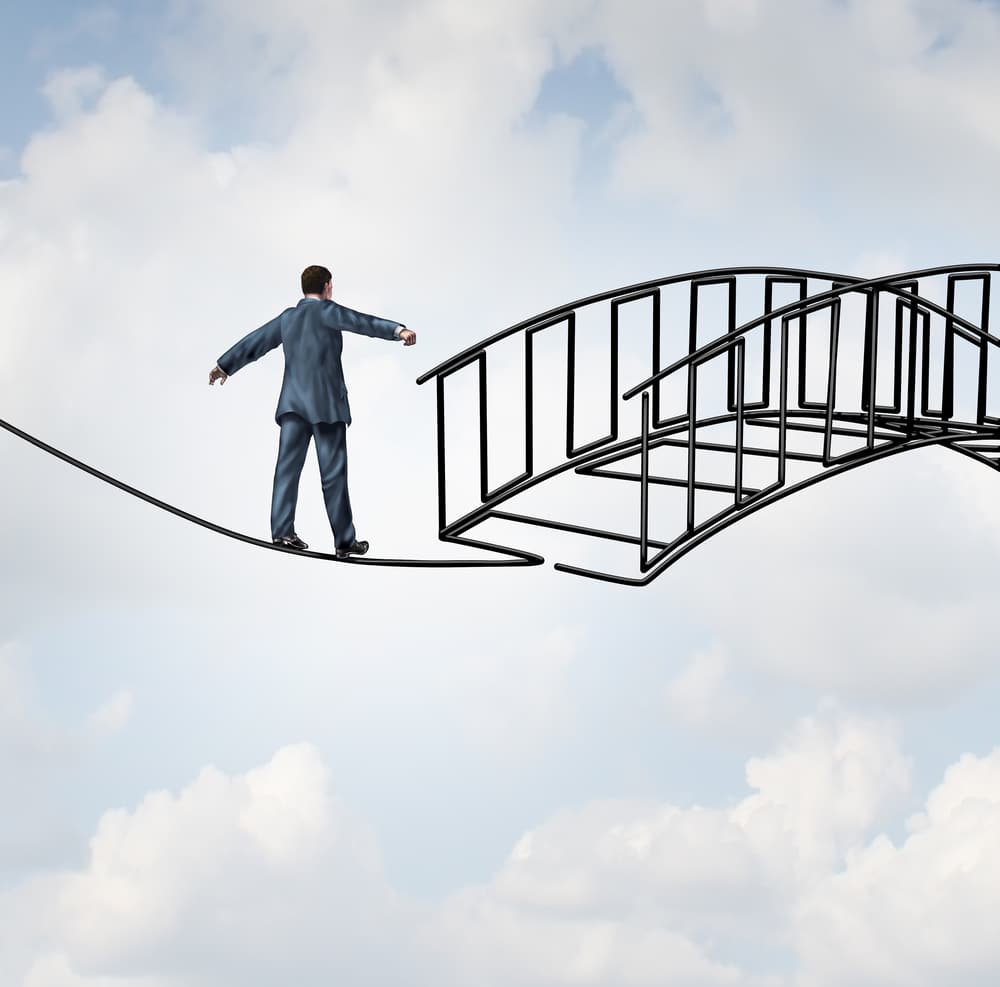 Man walking on a tightrope to a bridge