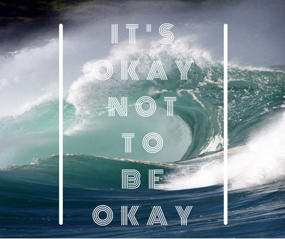Its okay not to be okay quote overlayed on a photograph of a large crashing wave