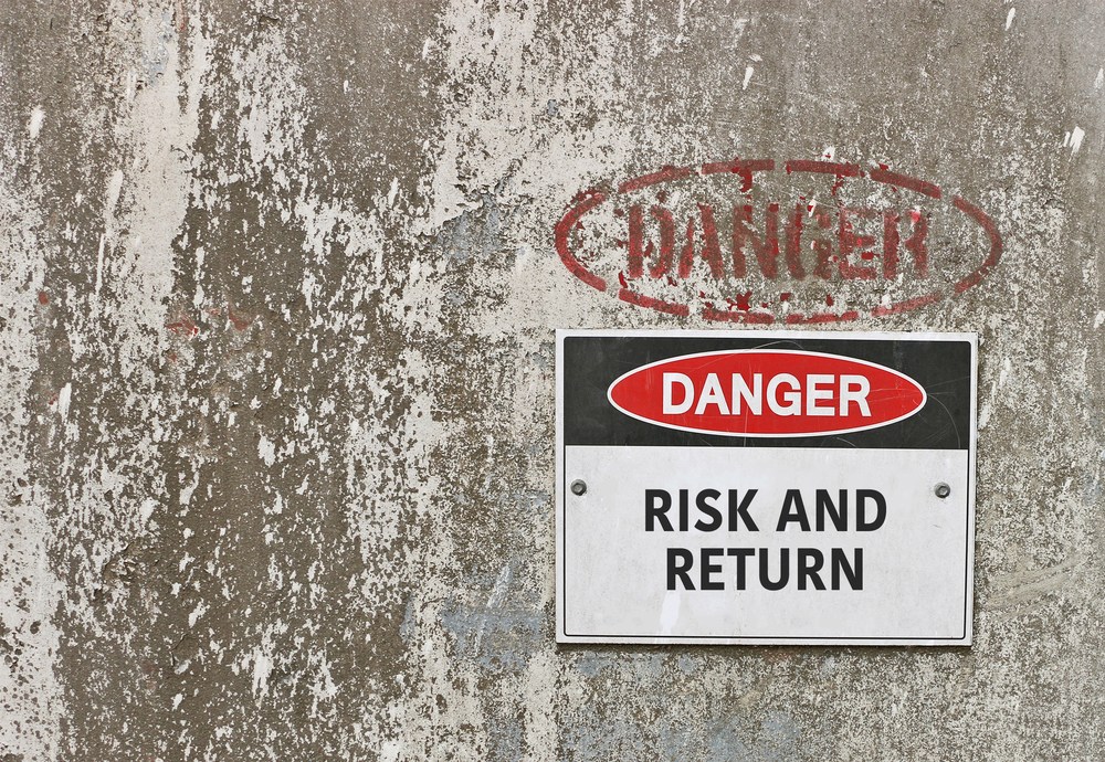 Danger Risk and Return sign on a distressed wall.