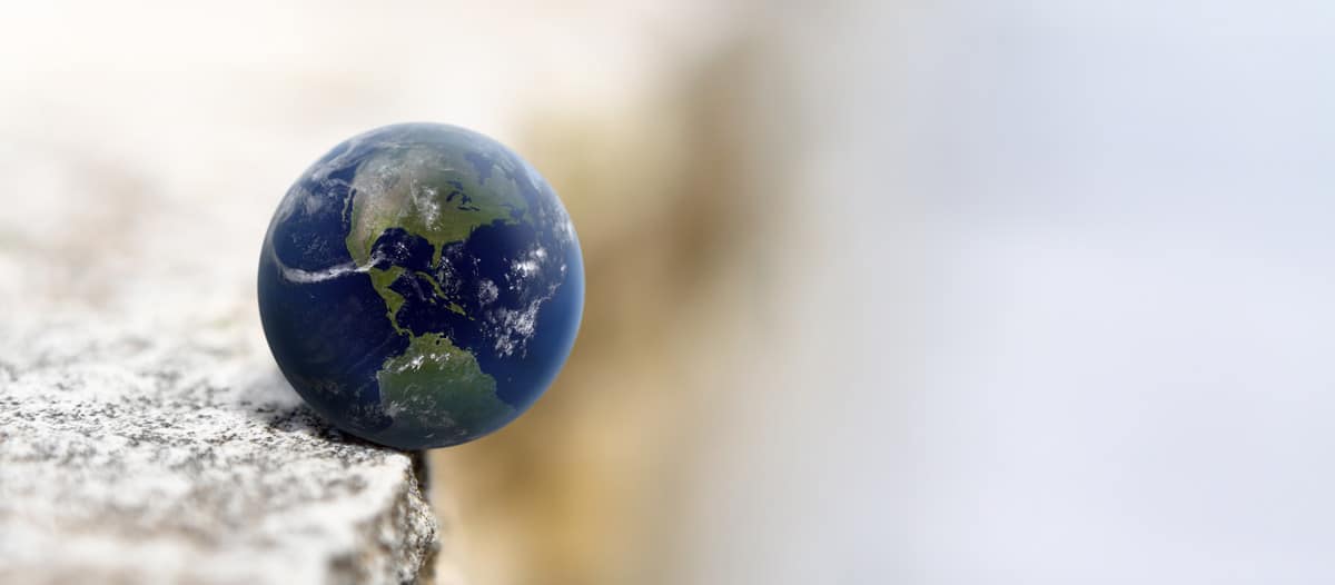 An image of a globe balancing on the edge of a rock to represent the winds of change in law practices