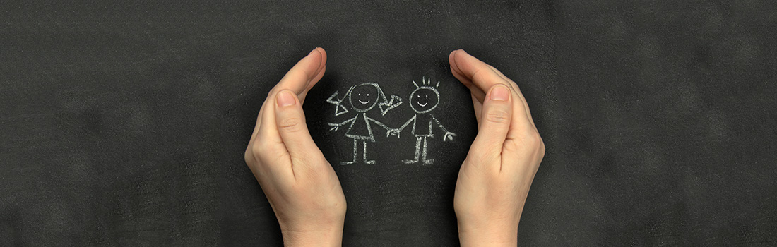 Stick figures of children drawn in chalk with a pair of protective hands around them