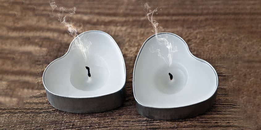 Heart shaped candles with smoking wicks - representing the end of a relationship